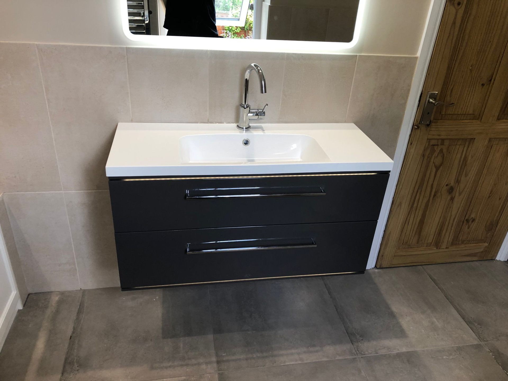 Fully tiled walk-in shower enclosure with rainfall head in a fitted bathroom